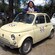 A smiling woman leaning over a FIAT